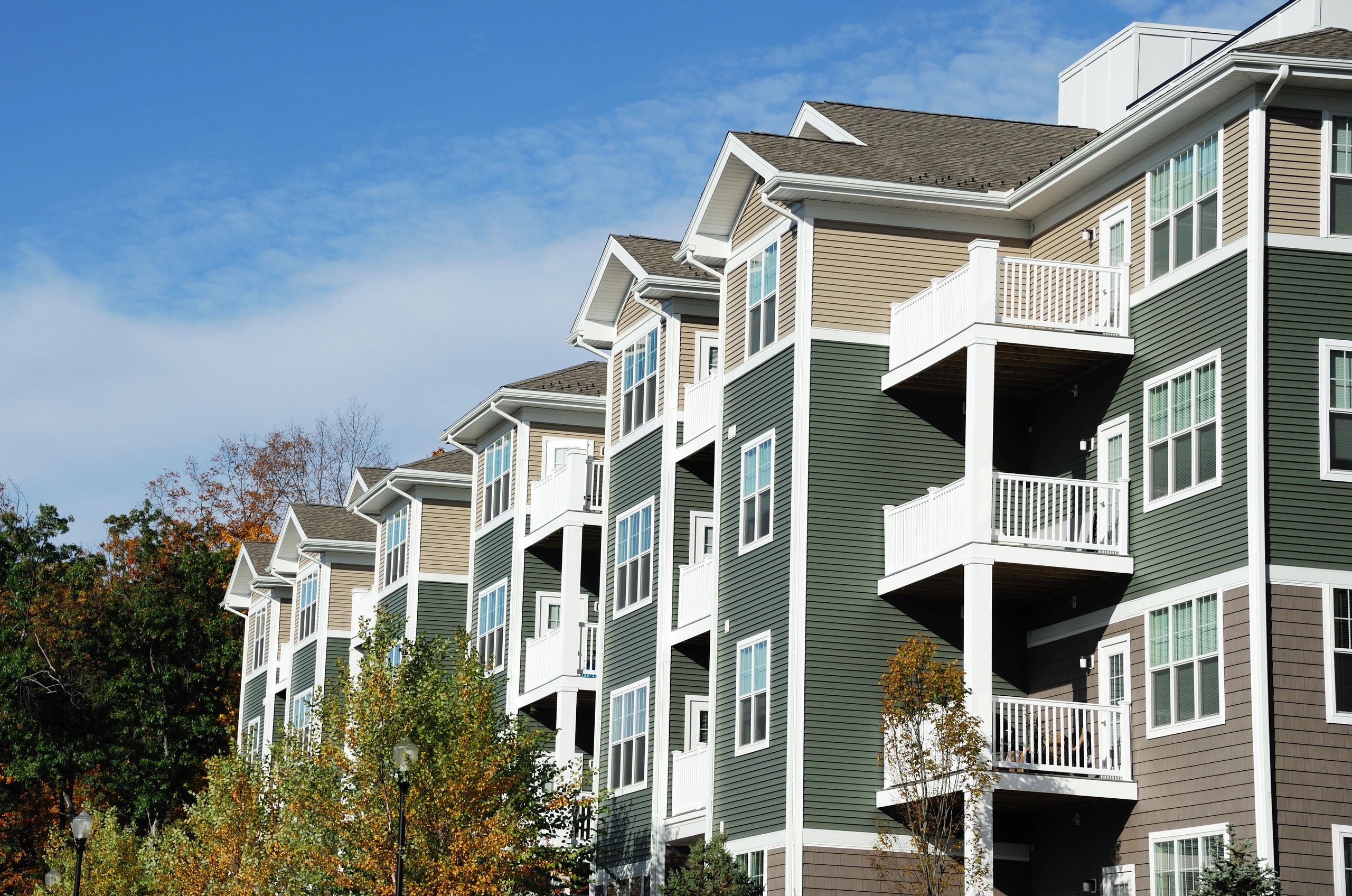 Apartment building with autumn trees landscape.